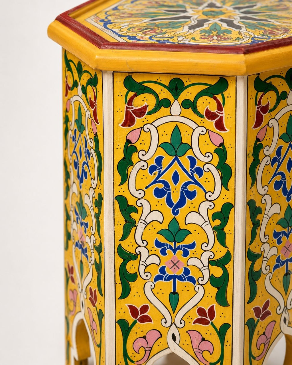 Top-down view of an octagonal wooden side table showcasing a symmetrical hand-painted mandala pattern.